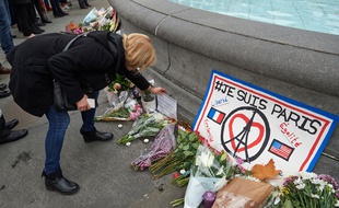 Une femme dépose une gerbe de fleurs en hommage aux victimes de l'attentat à Trafalgar Square.