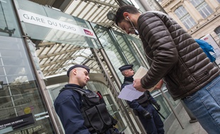 Des policiers contrôlent les attestations de déplacements des usagers, a l'entrée de la Gare du Nord, à Paris, le 21 mars 2020.