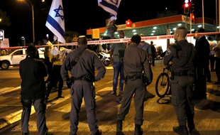 Les forces de sécurité israéliennes se tiennent derrière le périmètre de sécurité où Yehuda Glick, un militant d'extrême-droite israélien, a été blessé par balles mercredi 29 octobre