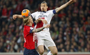 Lille, le 10 mai 2014. Match comptant pour la 37e journee du championnat de L1 de football qui opposait le Lille OSC (LOSC) au Paris SG (PSG) au stade Pierre-Mauroy. Ici le lillois Simon Kjaer a la lutte avec le parisien Zlatan Ibrahimovic.
