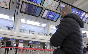 Un homme vérifie les horaires des avions à l'aéroport Houari Boumédiène d'Alger alors que certains vols intérieurs reprennent, le 6 décembre 2020.
