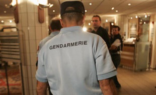 A French Gendarme enters the Mercure Hotel to inspect the premises after Rabobank team rider Michael Rasmussen of Denmark was sacked by his team for 'violating team rules' during the 94th Tour de France cycling race in France, July 26, 2007. REUTERS/Thierry Roge (FRANCE)