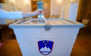 Un électeur dépose son bulletin dans l'urne le 20 décembre 2015 à Bled en Slovénie