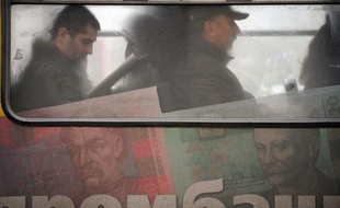 La valeur de la Hryvnia, la monnaie ukrainienne peinte ici sur les flancs d'un bus à Kiev, a été divisée par trois en un peu plus d'un an