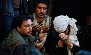 Des proches du journaliste afghan de l'AFP Sardar Ahmad prient durant ses funérailles à Kaboul le 23 mars 2014