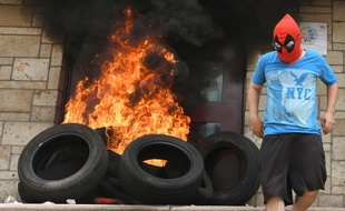 La porte de l'ambassade américaine incendiée au Honduras par des personnes masquées, en marge de manifestations, le 31 mai 2019.