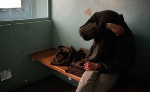 Un homme placé en cellule de garde à vue dans un commissariat.