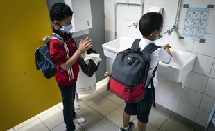 Dans une école toulousaine, deux élèves portant un masque et se lavant les mains.