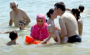 Illustration d'une femme portant un burkini à la plage.