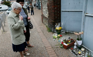 Des personnes se recueillent devant le domicile du prêtre Jacques Hamel, le 27 juillet 2016 à Saint-Etienne-du-Rouvray