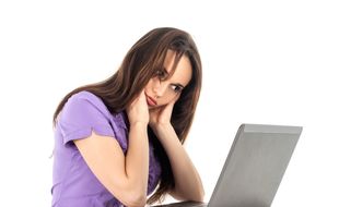 Une jeune femme regarde un ordinateur portable. Photo d'illustration.