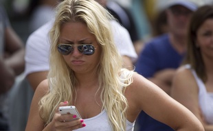 Une femme essaie son nouvel iPhone, à Miami, en 2012.