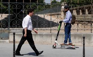 Un homme fait de la trottinette à Paris.