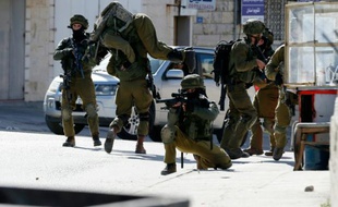 Un soldat israélien porte un de ses collègues blessé après des affrontements avec des Palestiniens dans le camp de réfugiés de Amari, près de Ramallah ke 15 février 2016