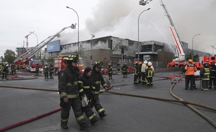 Des pompiers interviennent dans un supermarché incendié à Santiago, au Chili, le 20 octobre 2019.