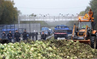 Des employés nettoient la chaussée le 27 octobre 2013 à Pont-de-Buis après les violentes manifestations contre l'écotaxe