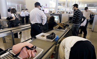 Des passagers passent les contrôles de sécurité, ici à l'aéroport de Roissy.