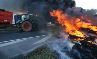 Des agriculteurs en colère brûlent des pneus et bloquent l'entrée de la ville le 15 février 2016 à Caen