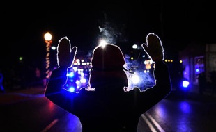 Un manifestant mains en l'air face à la police à Ferguson lors de manifestations le 25 novembre 2014