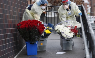 Des infirmières du service des urgences de l'hôpital Elmhurst à New York transportent des fleurs reçues en don, le 28 mars 2020.
