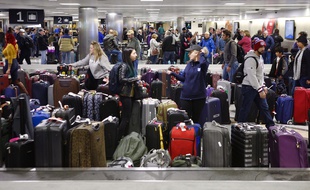 Des passagers viennent chercher des bagages après l'annulation des vols avant une tempête, le 16 janvier 2018 à l'aéroport de Houston aux Etats-Unis.