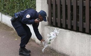 Un policier dépose une fleur à côté de la maison des policiers tués à Magnanville