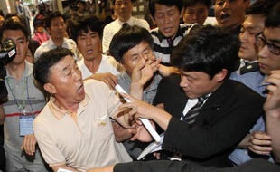 Des proches des victimes du ferry naufragé aux prises avec un officier de la sécurité le 10 juin 2014 à l'ouverture du procès de l'équipage à Gwangju