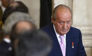 Le roi d'Espagne Juan Carlos signe la loi permettant son abdication, au palais royal de Madrid, le 18 juin 2014