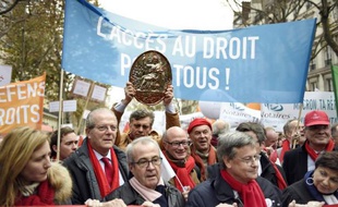 Un manifestant brandit un pannonceau de notaire lors d'une manifestations des professions juridiques qui contestent le projet de loi Macron, le 10 décembre 2014 à Paris