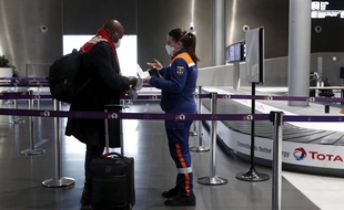 Une membre de la protection civile face à un voyageur à l'aéroport de Roissy. (illustration)