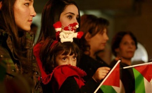Une famille chrétienne palestinienne assiste à un office avant Noël à l'église orthodoxe de Gaza le 22 décembre 2014