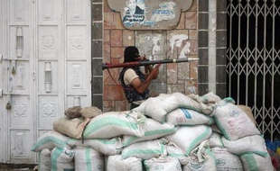 Un membre des milices pro-gouvernementales yéménites en position de combat le 24 avril 2015 dans une rue de la ville de Taëz, théâtre d'affrontements avec les rebelles chiites Houthis