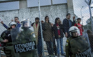La police grecque se tient devant le camp de Moria alors que les migrants manifestent contre l'accord entre la Turquie et l'Union européenne, à Lesbos le 24 mars 2016