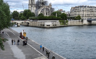 Les pompiers s'entrainent en contrebas de Notre-Dame, tandis que les ouvriers alpinistes tendent des baches pour proteger la Cathedrale.
