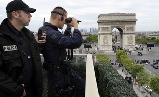 Des policiers observent les passants autour de l'Arc de Triomphe à Paris.