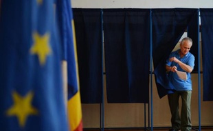 Un homme sort de l'isoloir après avoir voté pour les élections européennes à Bucarest le 25 mai 2014