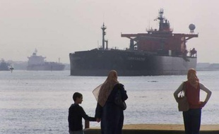 Des Egyptiens regardent un tanker transiter par le canal de Suez en 2008.