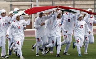 Les joueuses de l'équipe d'Iran de football courent avec leur drapeau national à Amman, avant un match de qualifications aux JO-2012 contre la Jordanie, qui n'a pas été disputé en raison de l'interdiction du voile islamique, le 3 juin 2011.