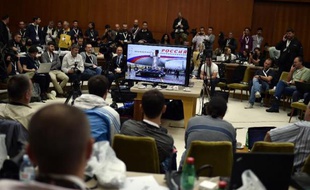 Des journalistes suivent l'arrivée du président russe Vladimir Poutine à Belgrade dans une salle de presse, le 16 octobre 2014