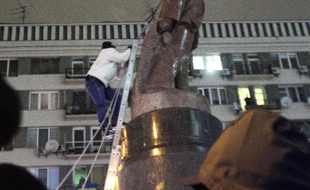 Un manifestant monte sur une statue de Lénine pour la déboulonner, dans le centre de Kiev le 8 décembre 2013