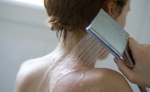 Jeune femme qui prend sa douche. (Illustration)