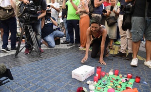 Une femme pose une bougie en mémoire des victimes des attentats de Catalogne, le 18 août 2017 à Barcelone. AFP PHOTO / JAVIER SORIANO
