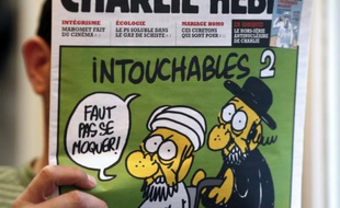 Un homme lit le 19 septembre 2012 le numéro de Charlie Hebdo paru ce jour-là, montrant un juif et un musulman sous le titre "Intouchables 2"