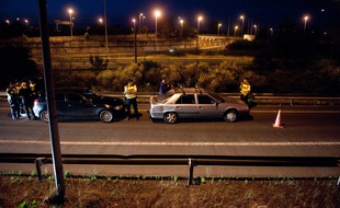 Illustration d'un contrôle routier en pleaine nuit à la sortie d'une autoroute.