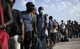 Une file de migrants et de migrantes à Lesbos.