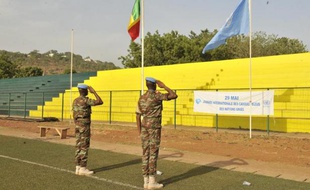Des casques bleus de la Mission des Nations unies au Mali, la Minusma, saluent les drapeaux malien et onusien le 29 mai 2015 à Bamako