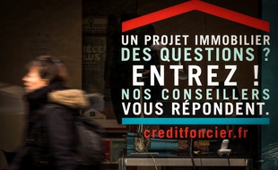 Devant une publicité pour un crédit immobilier.
