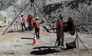 Des ouvriers autour de l'installation qui permet de communiquer avec les mineurs bloqués à 700 mètres de profondeur au Chili, le 29 août 2010.