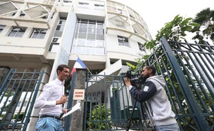 Entrée du commissariat central de Saint-Denis à La Réunion le 2 juin 2015, où un cameraman filme un journaliste relatant l'arrestation d'un groupe présumé de jihadistes
