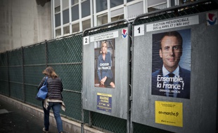 Marine LE PEN (FN Front National) et Emmanuel MACRON (EM En Marche).
Affiches offcielles sur les panneaux electoraux, devant un bureau de vote parisien, des candidats finalistes a l'election presidentielle francaise. Paris, le 3 Mai 2017